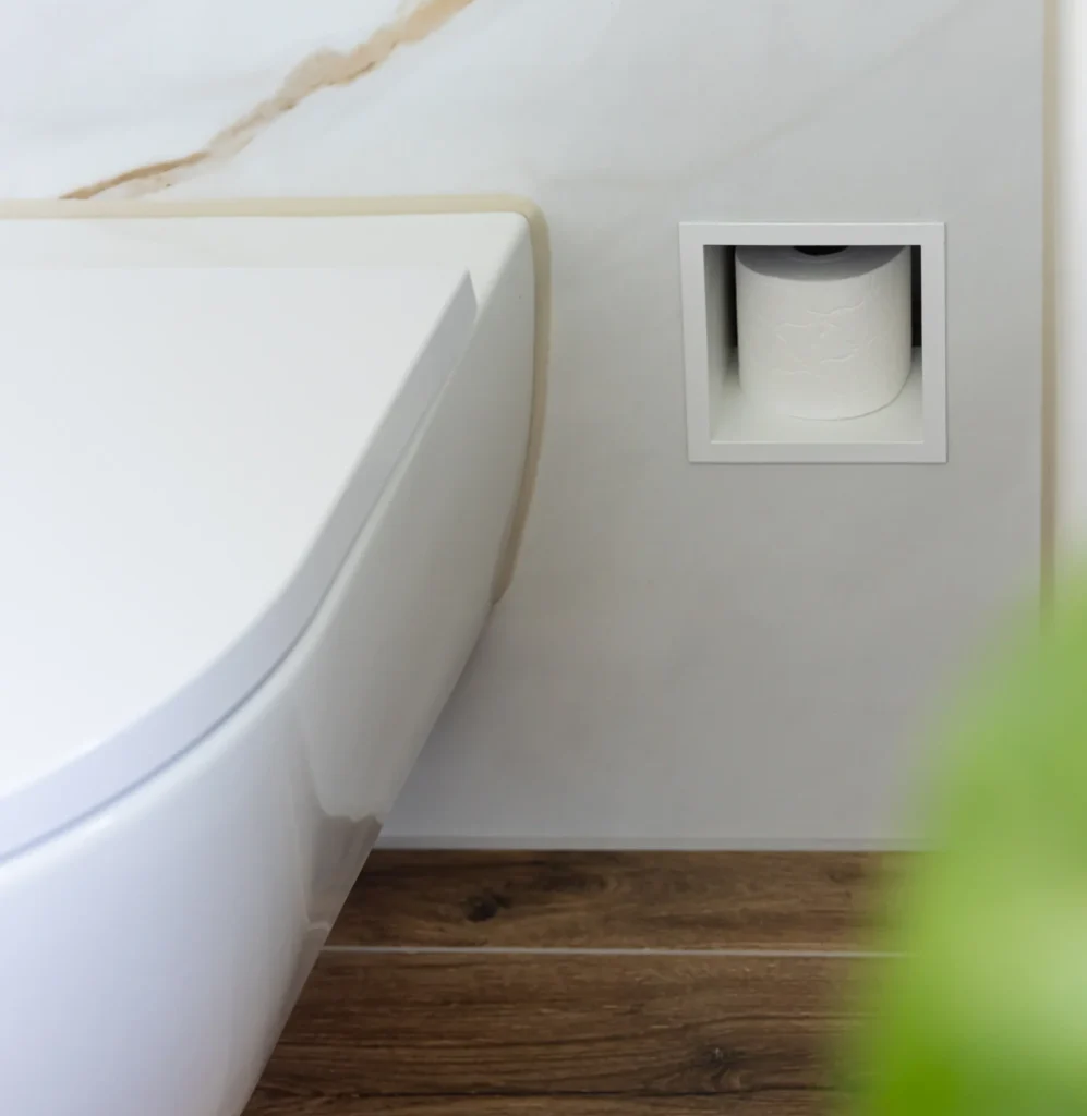 Close up van toilet met ingebouwde toiletrolhouder in de muur