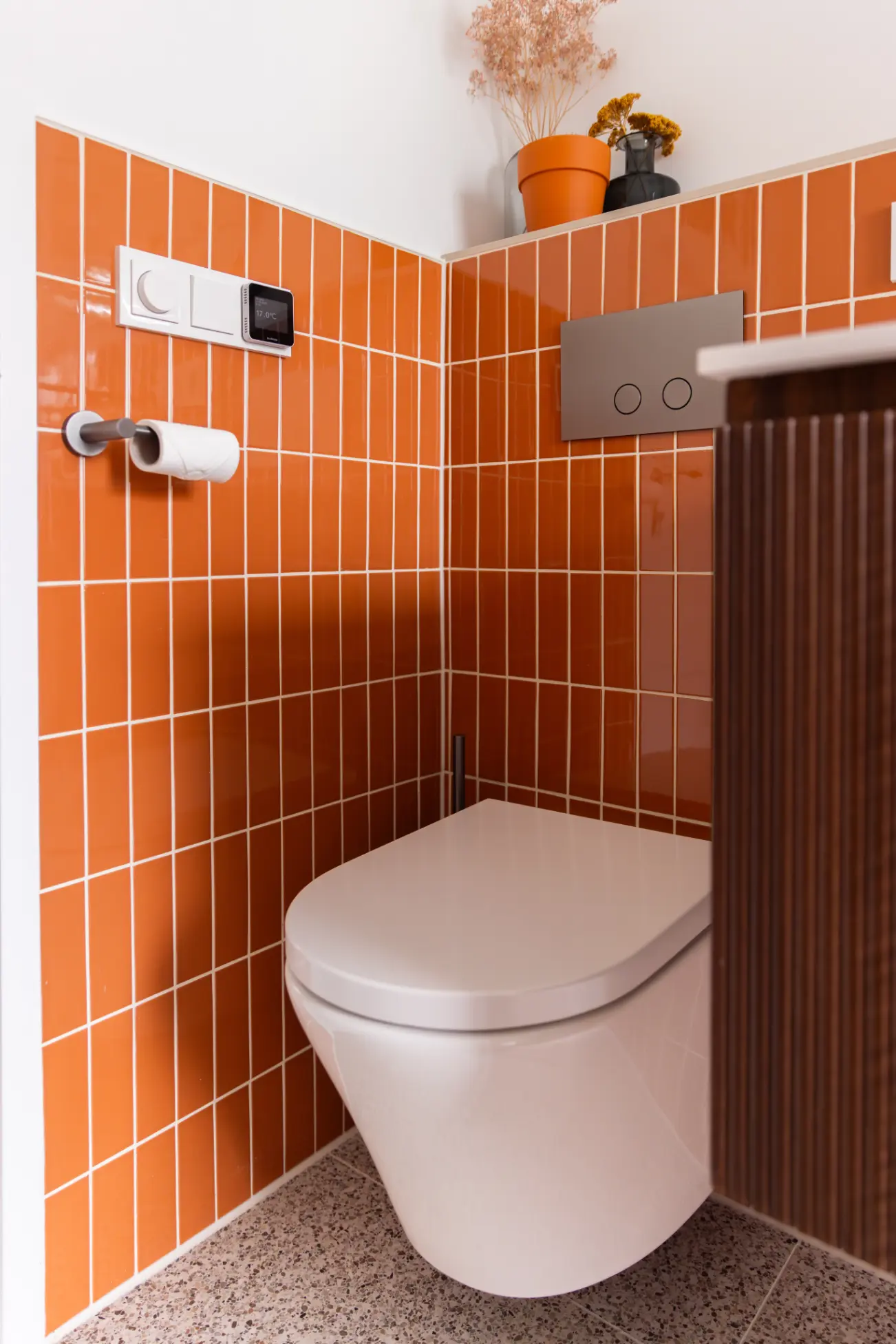 Modern toilet met oranje wandtegels
